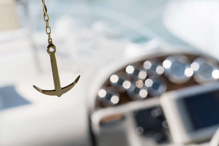 sea Golden anchor on the background of a bokeh yacht in the sea in the sunの写真素材