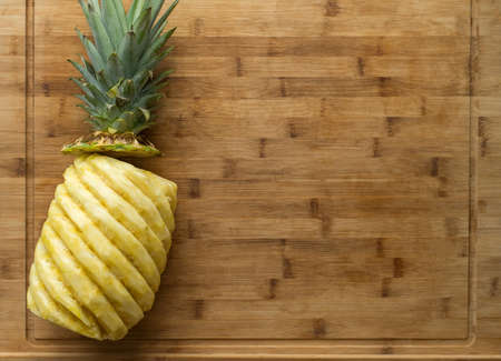 Ripe perfectly peeled yellow pineapple, on a wooden background.の写真素材