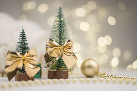 Two little Christmas trees decorated and gifts for the new year on the bokeh background, new year mood 2021の写真素材