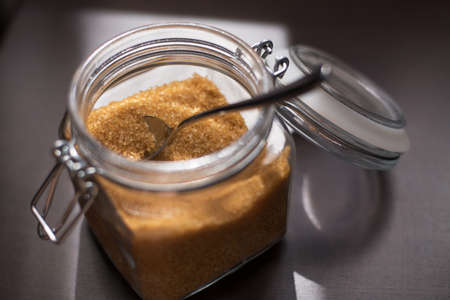 Transparent glass jar with brown sugar cane on a black background.の写真素材
