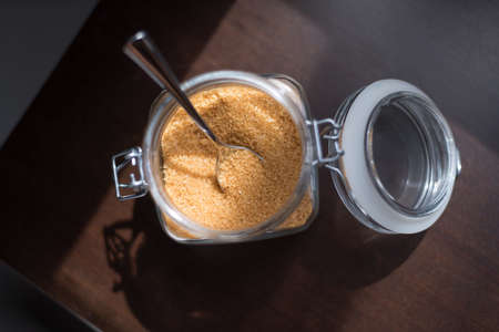 Transparent glass jar with brown sugar cane on a black backgroundの写真素材