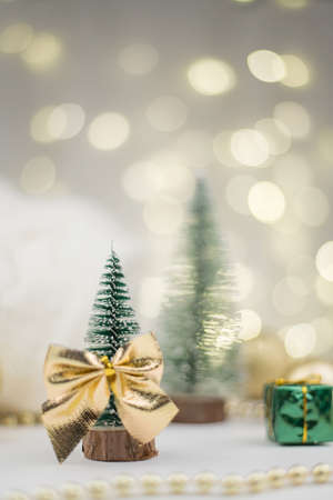 Little Christmas trees decorated and gifts for the new year on the bokeh background, new year compositionの写真素材