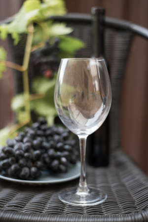 glass and bottle of dark red wine and grapes on a dark backgroundの写真素材