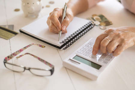 Old women's hands count expenses, plan a budget the concept of retirement, savings, old ageの写真素材