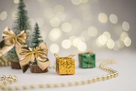 decorative Christmas trees decorated and gifts for the new year on the background of Golden bokeh lights, new year background, new year mood 2021.の写真素材