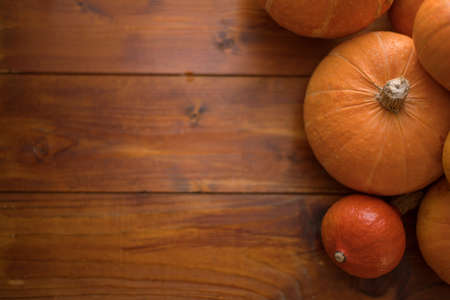 Autumn small orange pumpkin on a wooden table, the harvest, the symbol of Halloween.の写真素材