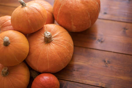 Autumn small orange pumpkin on a wooden table, the harvest, the symbol of Halloween.の写真素材
