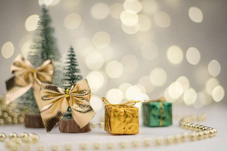 decorative Christmas trees decorated and gifts for the new year on the background of Golden bokeh lights, new year background, new year mood 2021.の写真素材