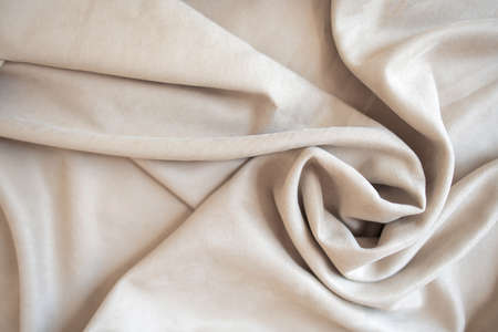 Beige velor pleats. Slight carelessness when folding the material. Soft blackout curtains for the room or kitchen. Fabric for tailoring.の写真素材