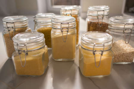 Collection of grain products in storage jars over on kitchen. Jar of cereals in kitchen cupboardの写真素材