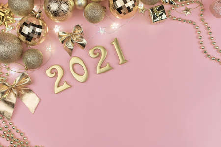 New year 2021 Golden numbers in the design of the Golden Christmas decor on a pink background.の写真素材