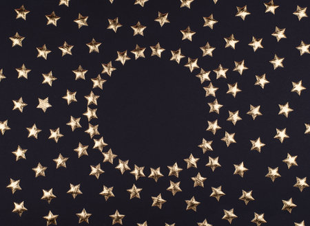 Round frame of festive holiday black background with shiny stars. Flat lay, top view of the Christmas or new Year pattern. copy space. Mock up.の写真素材