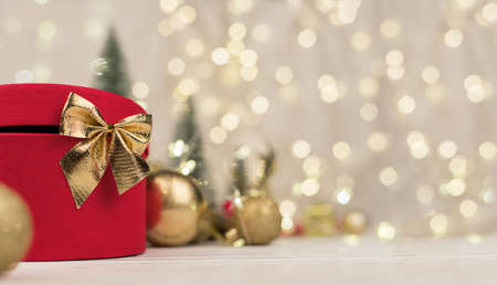 Christmas background, gift box with a Golden bow on the background of Christmas bokehの写真素材