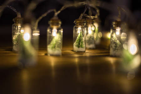 Low key Image of christmas tree in mason jar with garland warm lights.の写真素材
