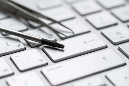 Laptop repair, screwdrivers close-up on a gray keyboard. Computer service macroの写真素材
