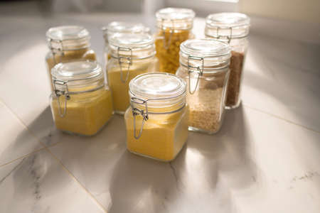 Collection of grain productsin storage jars over on kitchen. Jar of cereals in kitchen cupboardの写真素材