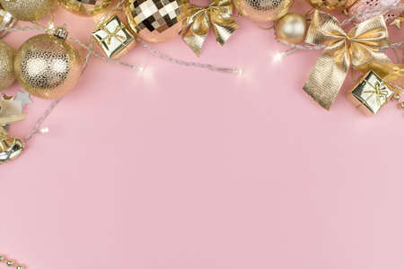 Merry Christmas background concept, new year card gold decoration frame on pink pastel table, flatly, copy space.の写真素材