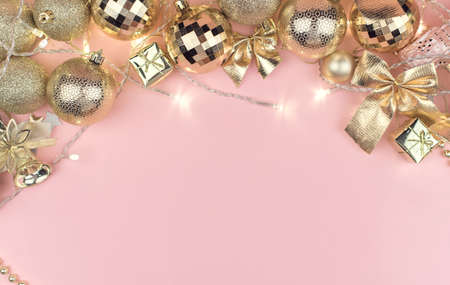 Merry Christmas background concept, new year card gold decoration frame on pink pastel table, flatly, copy space.の写真素材