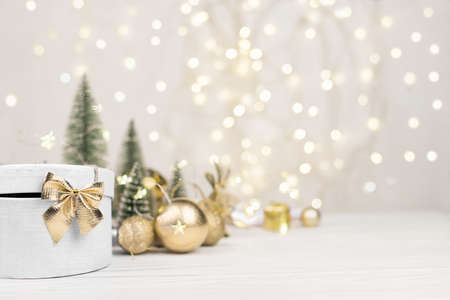 Christmas background, gift box with a Golden bow on the background of Christmas bokehの写真素材