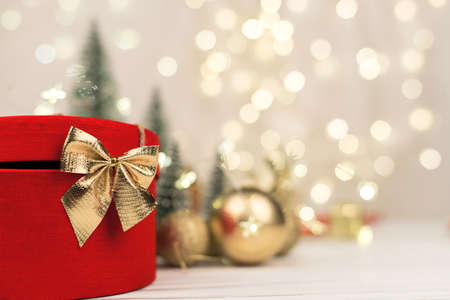Christmas background , red gift box with a Golden bow on the background of Christmas bokeh. Copy Spaceの写真素材