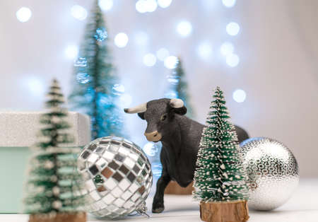 decorative bull symbol of New Year on the background of Christmas tree and bokehの写真素材
