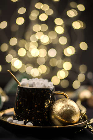 Homemade dark hot chocolate cocoa with marshmallows on a black Christmas background with Golden bokehの写真素材