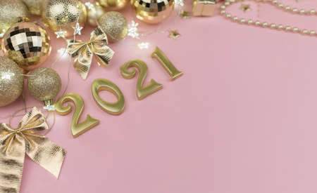 New year 2021 Golden numbers in the design of the Golden Christmas decor on a pink backgroundの写真素材