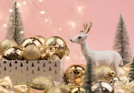 lots of Golden Christmas balls with deer on pink background, New Year background bokehの写真素材