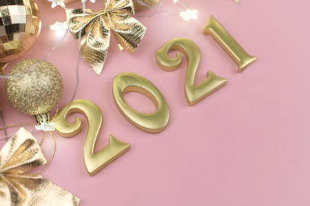 New year 2021 Golden numbers in the design of the Golden Christmas decor on a pink background.の写真素材