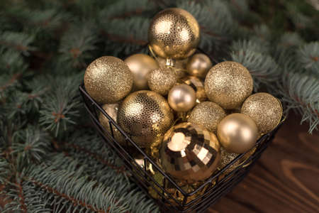 Stylish box of Christmas Golden toys on a wooden background and branches of Christmas trees.の写真素材