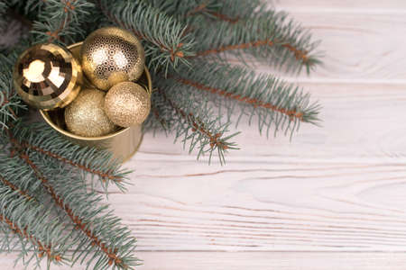 Stylish bucket of Christmas Golden toys on a wooden background and branches of Christmas trees.の写真素材