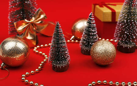 Decorated Christmas tree with a bow and gifts on red backgroundの写真素材