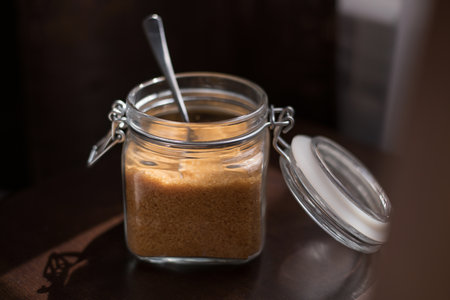 Transparent glass jar with brown sugar cane on a black backgroundの写真素材
