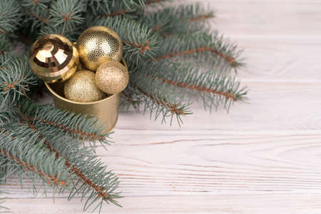 Stylish bucket of Christmas Golden toys on a wooden background and branches of Christmas trees.の写真素材