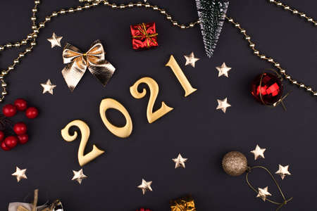Happy New Year 2021. Sparkling gold numbers on black background with stars and gifts. object for design holiday greeting card,の写真素材