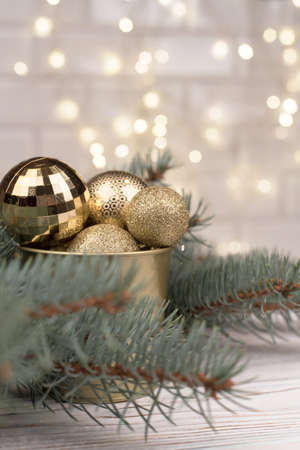 Stylish bucket of Christmas Golden toys on a wooden background and branches of Christmas trees.の写真素材