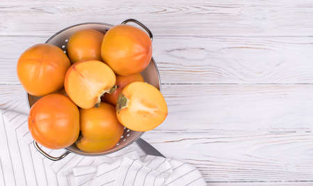 Delicious ripe persimmon fruit on wooden background.の写真素材