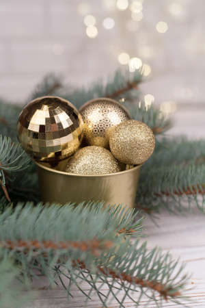 Stylish bucket of Christmas Golden toys on a wooden background and branches of Christmas trees.の写真素材