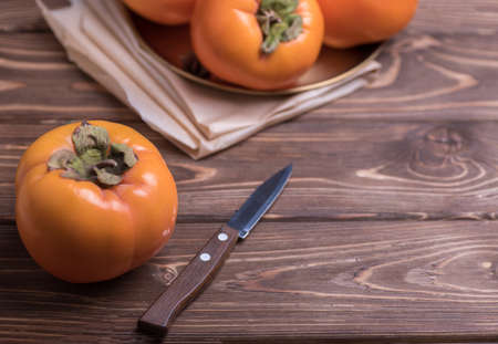 Delicious fresh orange persimmon fruit on wooden tableの写真素材