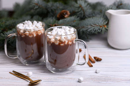 Glass cup of hot cocoa with christmas tree on the buckground of gold bokeh, New Year hot drink.の写真素材