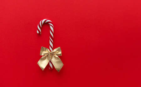 A candy cane with a bow on a red background, Candy caneの写真素材