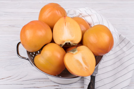Delicious ripe persimmon fruit on wooden background.の写真素材