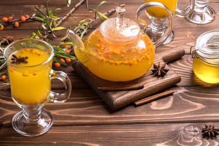 Beautiful glass teapot with sea buckthorn tea. Hot winter drinks.の写真素材