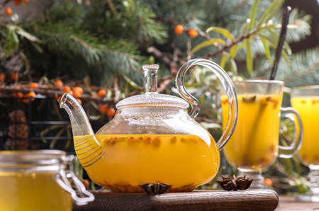 Beautiful glass teapot with sea buckthorn tea. Hot winter drinks.の写真素材