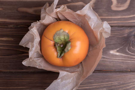 Delicious fresh orange persimmon fruit on wooden table.の写真素材