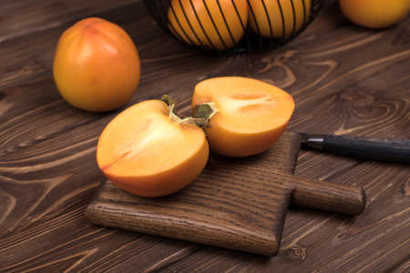 Delicious ripe persimmon fruit on wooden background.の写真素材