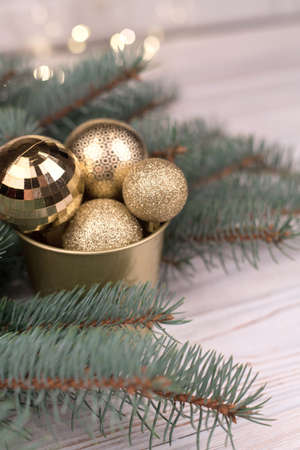 Stylish bucket of Christmas Golden toys on a wooden background and branches of Christmas trees.の写真素材