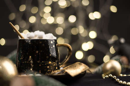 Homemade dark hot chocolate cocoa with marshmallows on a black Christmas background with Golden bokeh.の写真素材