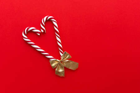 Two candy canes making a heart on a red textured background, Candy cane heartの写真素材