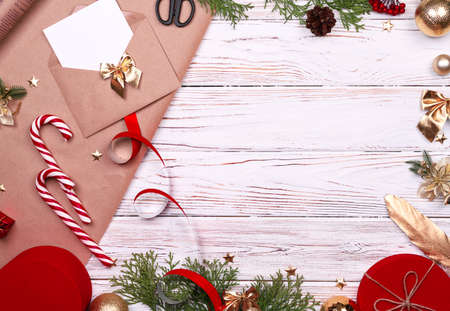 Gift wrapping. Packaging modern christmas present boxes in stylish gray paper with satin red ribbon. Top view table with fir tree branches, decoration of gift.の写真素材